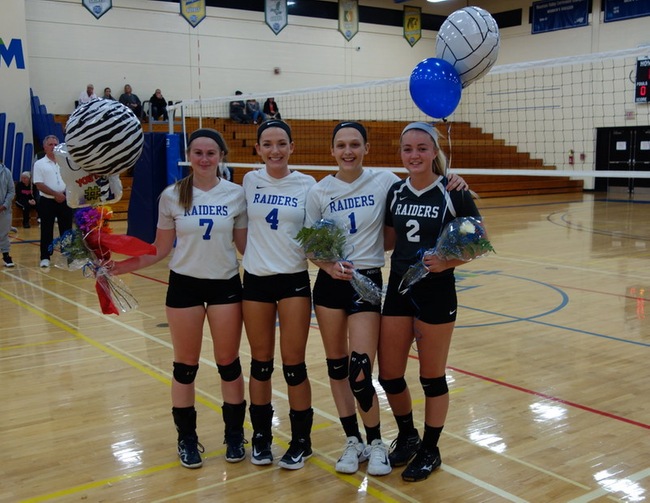 Photo Left to Right: Gabrielle Smith, Megan Ryder, Bri Eagan, and Julie Hampton celebrate senior night in the raiders den gym.  The seniors are holding balloons and flowers in celebration. 